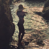 Lisa Haydon flaunts her third baby bump in a bikini as she poses on a beach